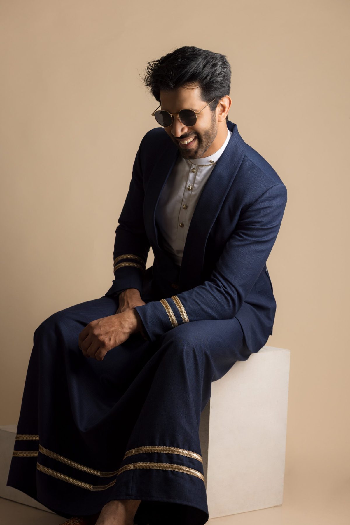 Groom in a navy Aarya Sinhala outfit with gold detailing